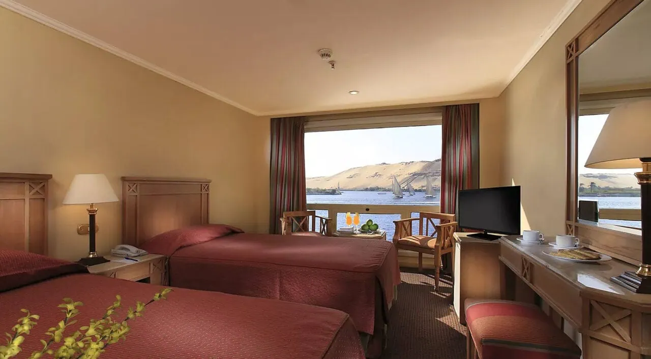 Cabina confortevole della Jaz Jubilee con letto matrimoniale e finestra panoramica sul Nilo