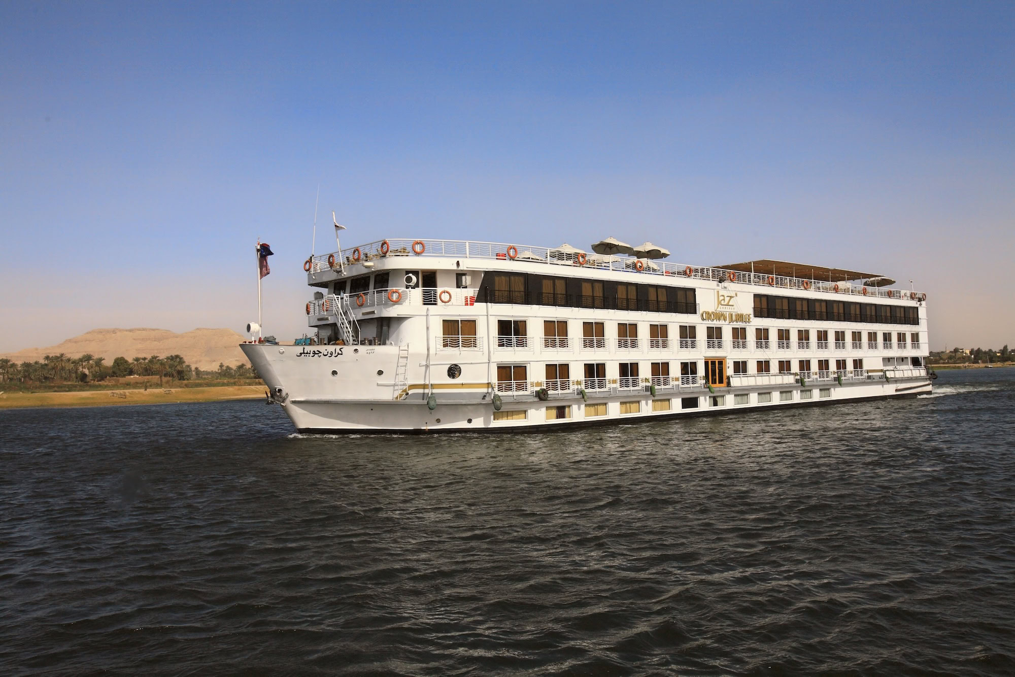 Modern Nile cruise ship with multiple decks and passenger facilities sailing along river