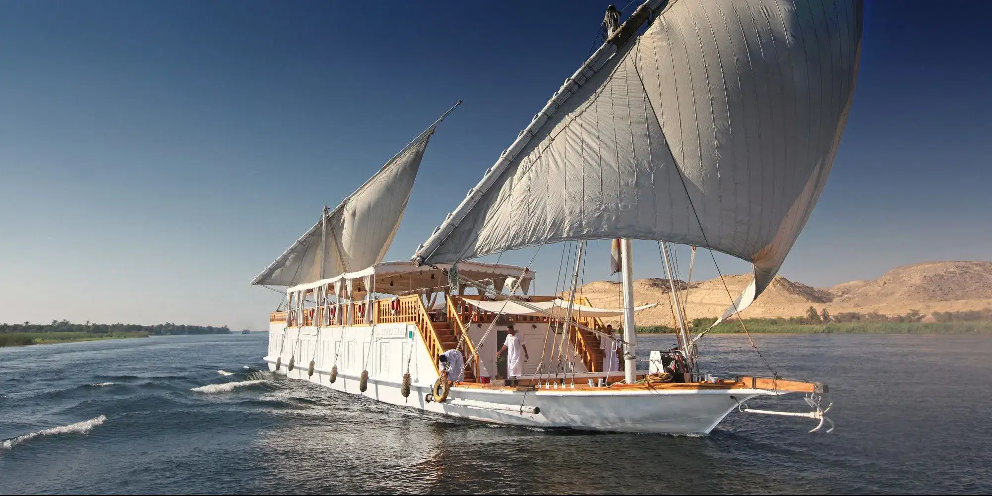 Traditional dahabiya sailboat with white sails on the Nile River, Aswan
