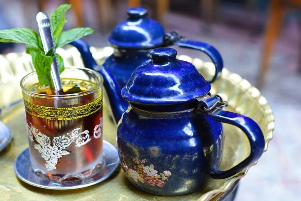 Mint tea served in a traditional glass with metal teapot at a café setting, Khan El-Khalili, Cairo