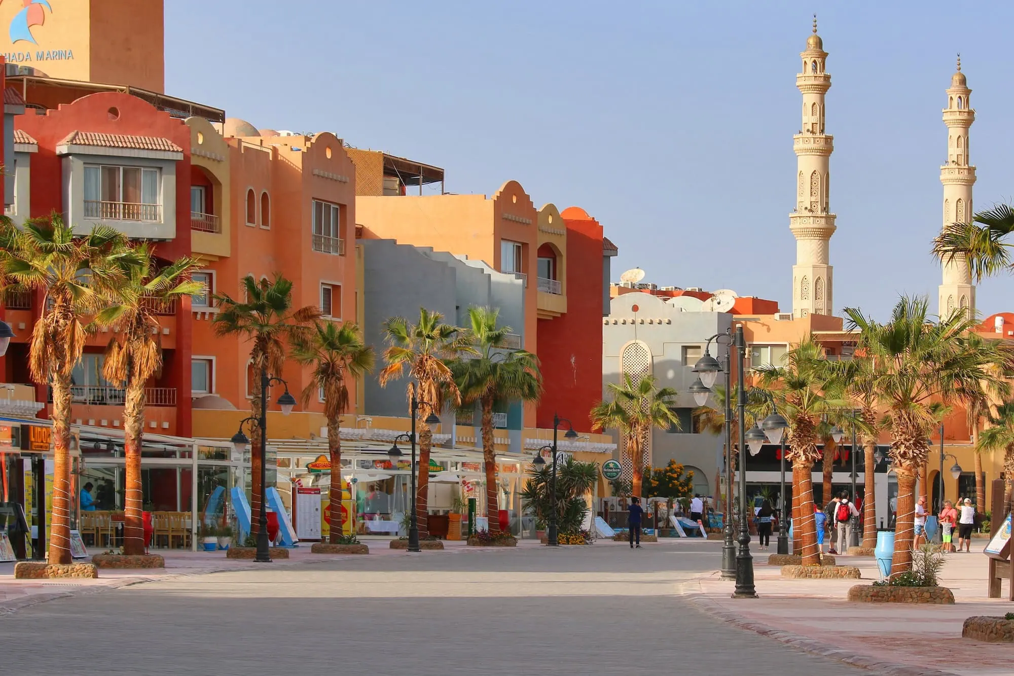 Marina Boulevard entertainment district with colorful buildings, shops, and pedestrians in plaza setting