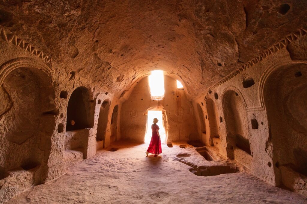 Silhouette of a woman inside a rock-cut cave church in Cappadocia, Cappadocia