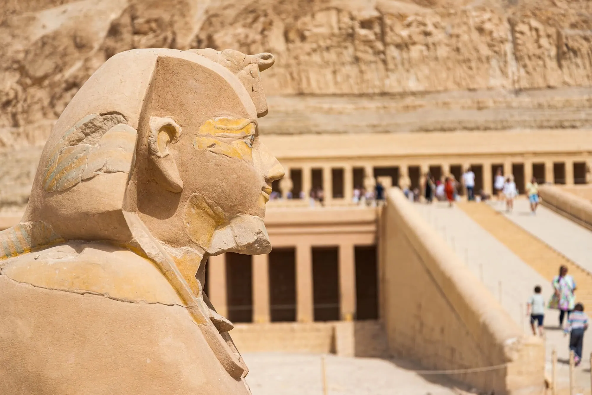 Sphinx statue at Hatshepsut's temple with ancient hieroglyphics and columns