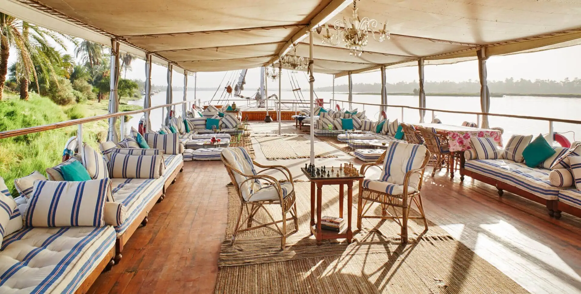 Elegant traditional Nile cruise boat deck with chandelier, chess set, and luxurious lounge seating