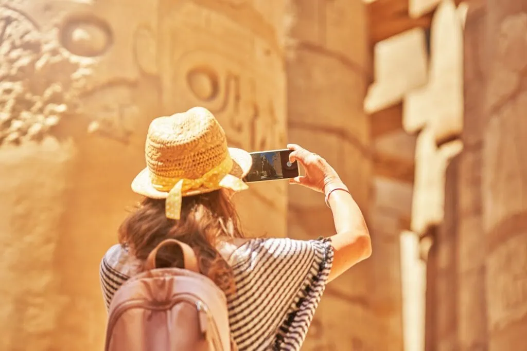 A woman walking among massive carved stone columns, Karnak Temple, Luxor