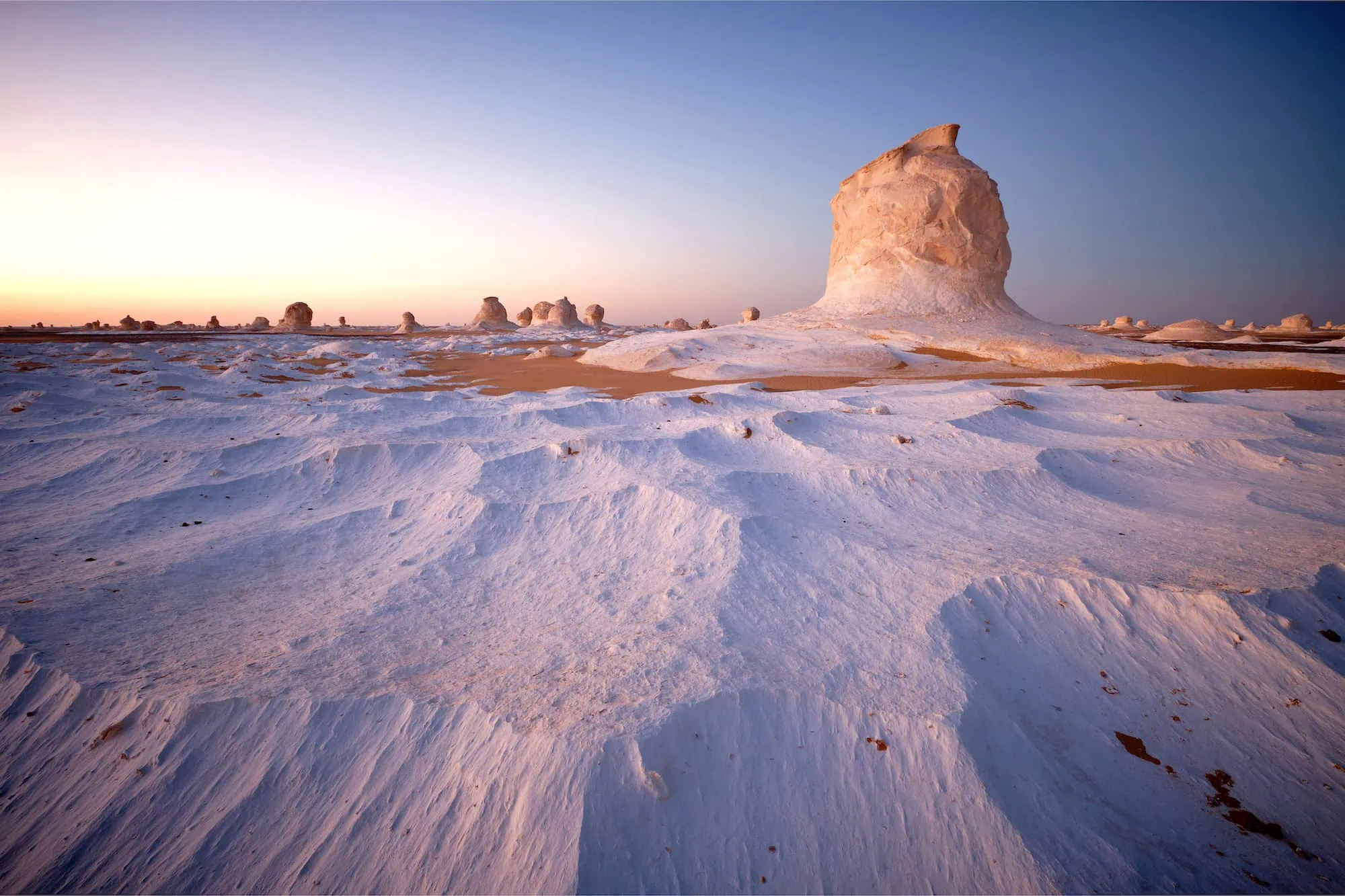 White limestone formations in Egypt's White Desert during sunset