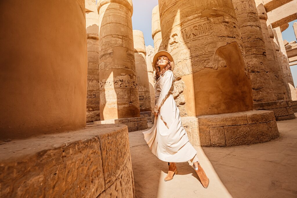 Traveler exploring the hypostyle hall columns of Karnak Temple