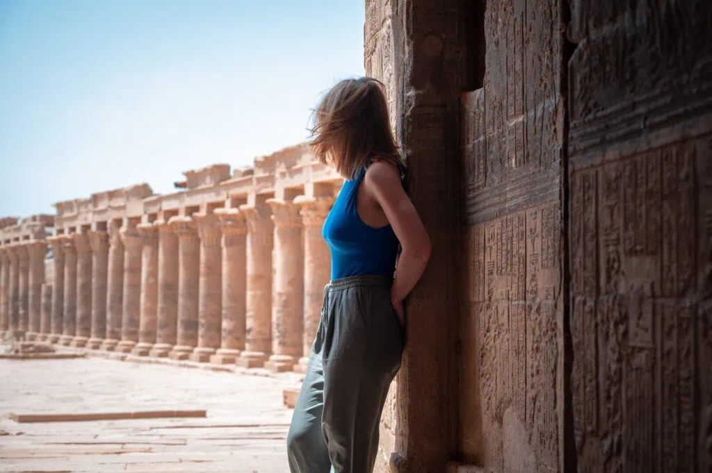Woman seen from behind looking toward the structures of Philae Temple