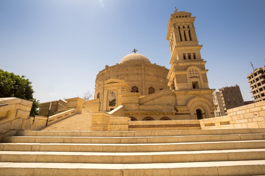 The Hanging Church and the Church of St. George with stone facades, bell towers, and surrounding historic courtyard, Cairo
