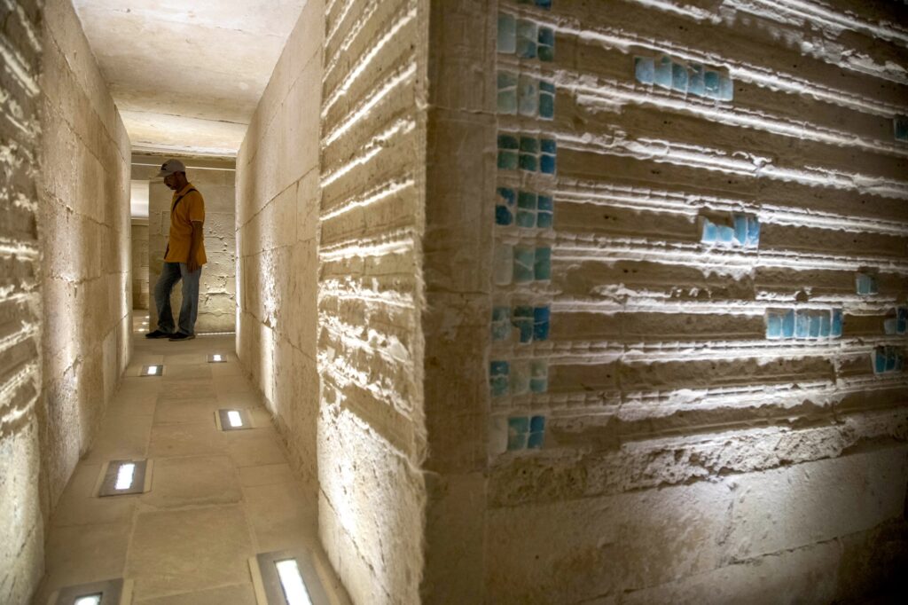 Interior corridor with limestone walls and blue tile inlays inside the Step Pyramid of Djoser, Saqqara