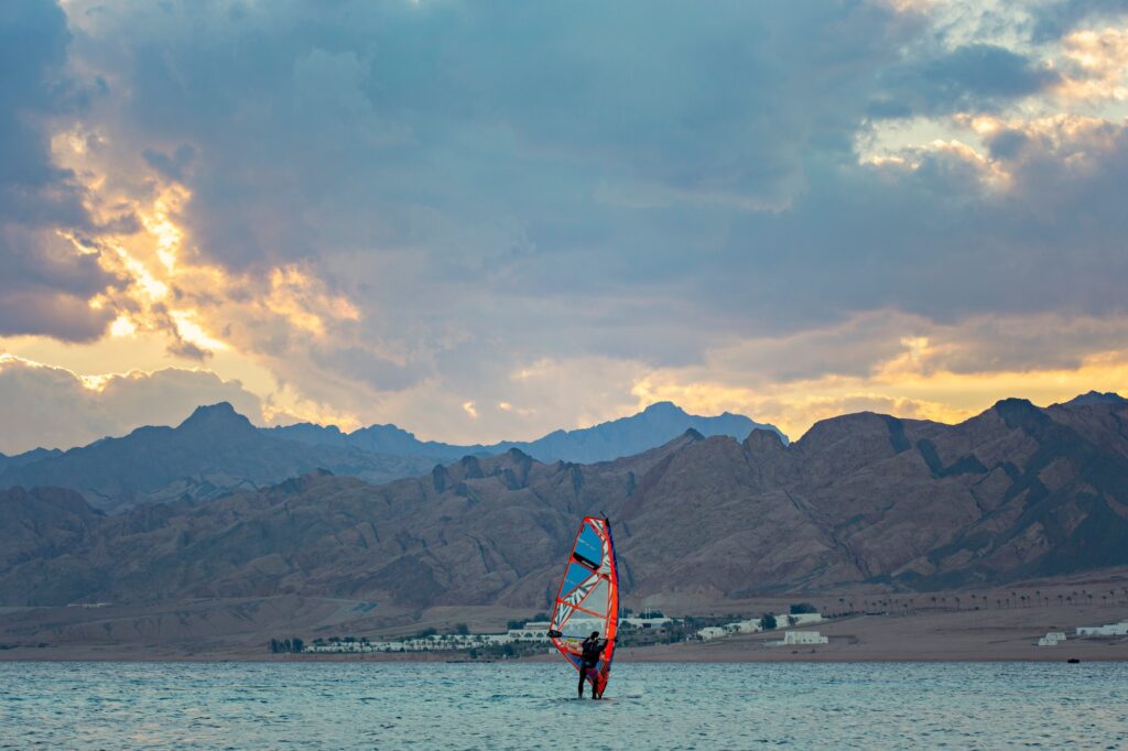 Windsurfer riding across the lagoon waters at sunset, Dahab