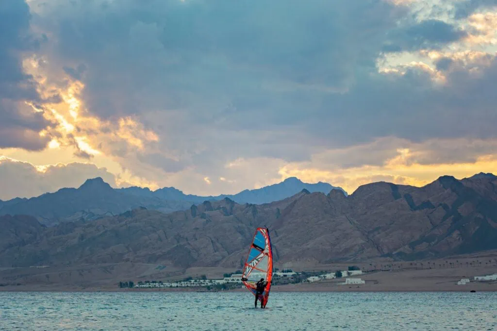 Windsurfer riding across the lagoon waters at sunset, Dahab