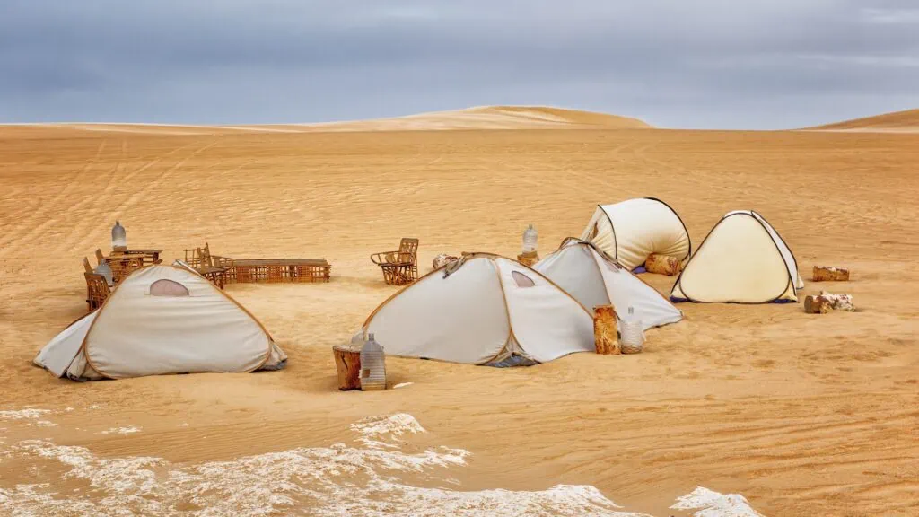 Tents set up on sandy terrain with surrounding dunes at Siwa Desert, Siwa