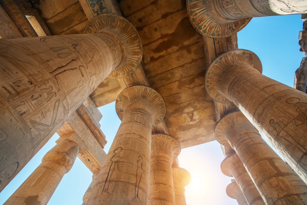 Stone columns with carved reliefs standing within the ruins of the Ramesseum, Luxor