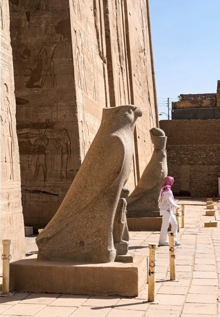 Carved granite statues of Horus flanking the entrance pylon of Edfu Temple, Edfu