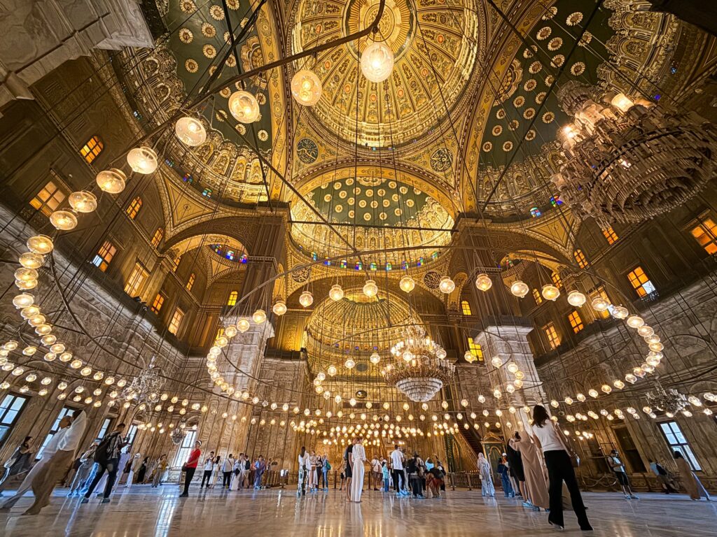 Interior view of Muhammad Ali Mosque with visitors beneath chandeliers inside the Citadel of Cairo, Cairo