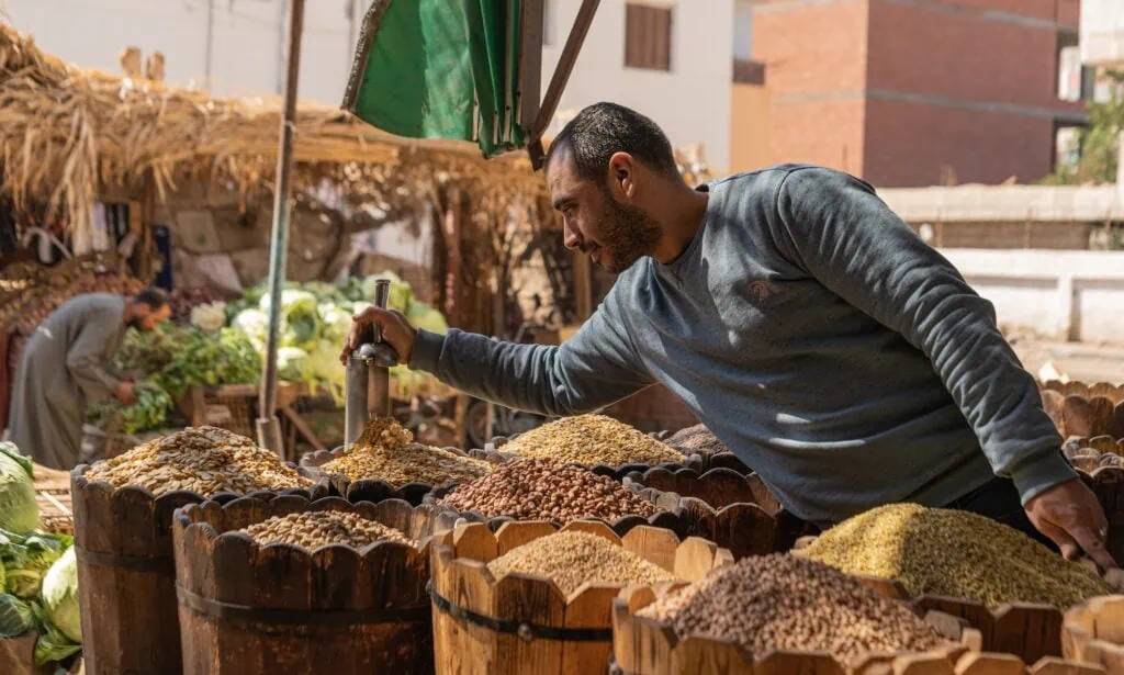 Vendors selling dried food products at a traditional street market stall