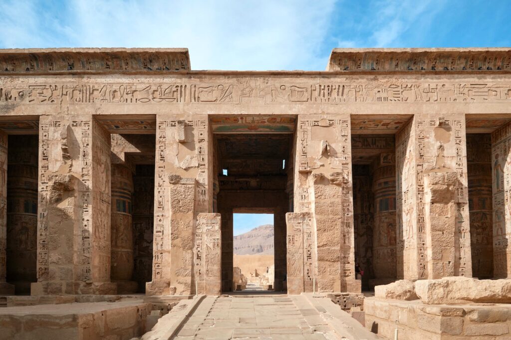 Massive stone pylons, relief-carved walls, and enclosed courtyards of the Mortuary Temple of Ramesses III at Medinat Habu, Luxor