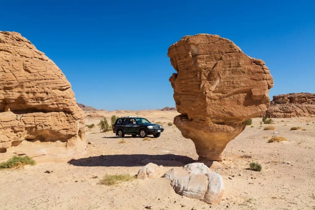 Car parked beside Mushroom Rock formation in Sinai Desert, Dahab
