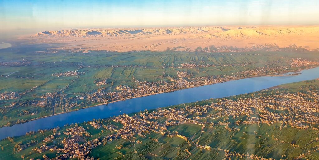 Aerial view of the Nile River with fertile green banks contrasting the Theban Hills and desert landscape, Luxor