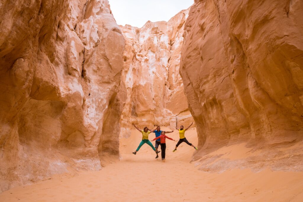 Tourists walking among white limestone walls and narrow passages in the White Canyon, Nuweiba