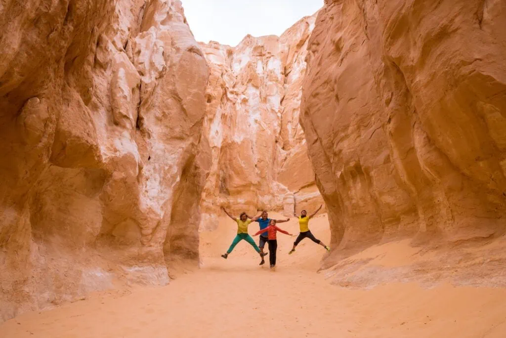 Tourists walking among white limestone walls and narrow passages in the White Canyon, Nuweiba