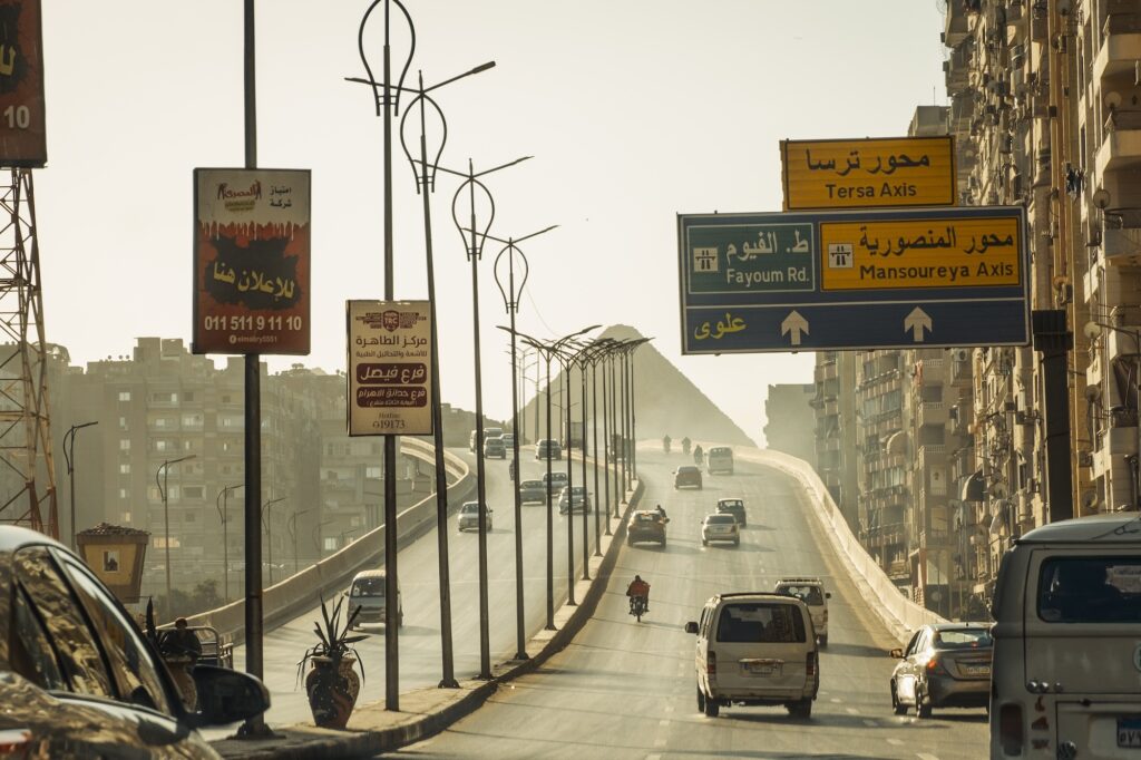 Traffic road with view of the Pyramids of Giza on the outskirts of Cairo, Cairo