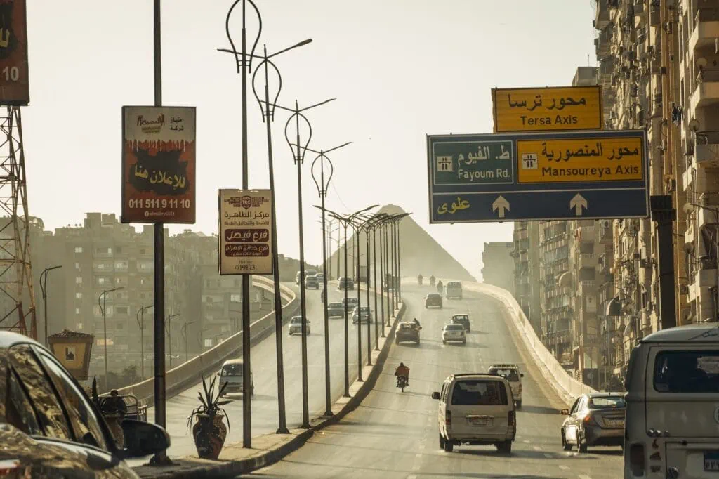 Traffic road with view of the Pyramids of Giza on the outskirts of Cairo, Cairo