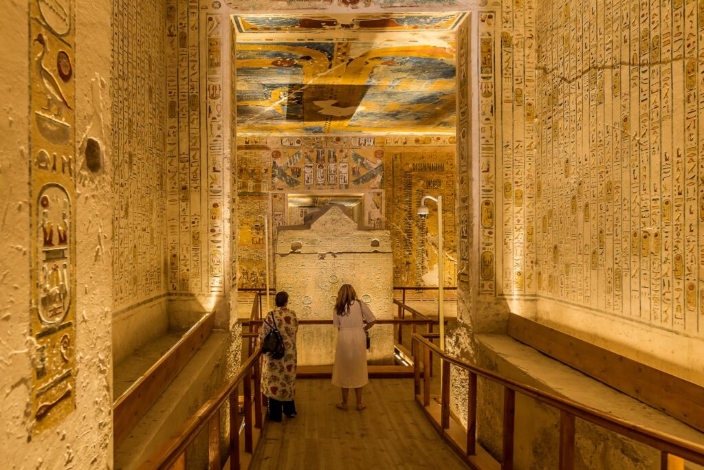 Interior of the tomb KV 2 of Ramses IV showing wall reliefs with two tourists inside, Valley of the Kings, Luxor