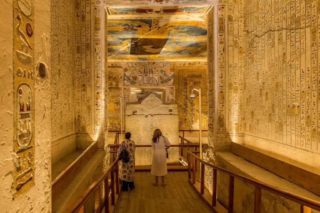 Interior of the tomb KV 2 of Ramses IV showing wall reliefs with two tourists inside, Valley of the Kings, Luxor