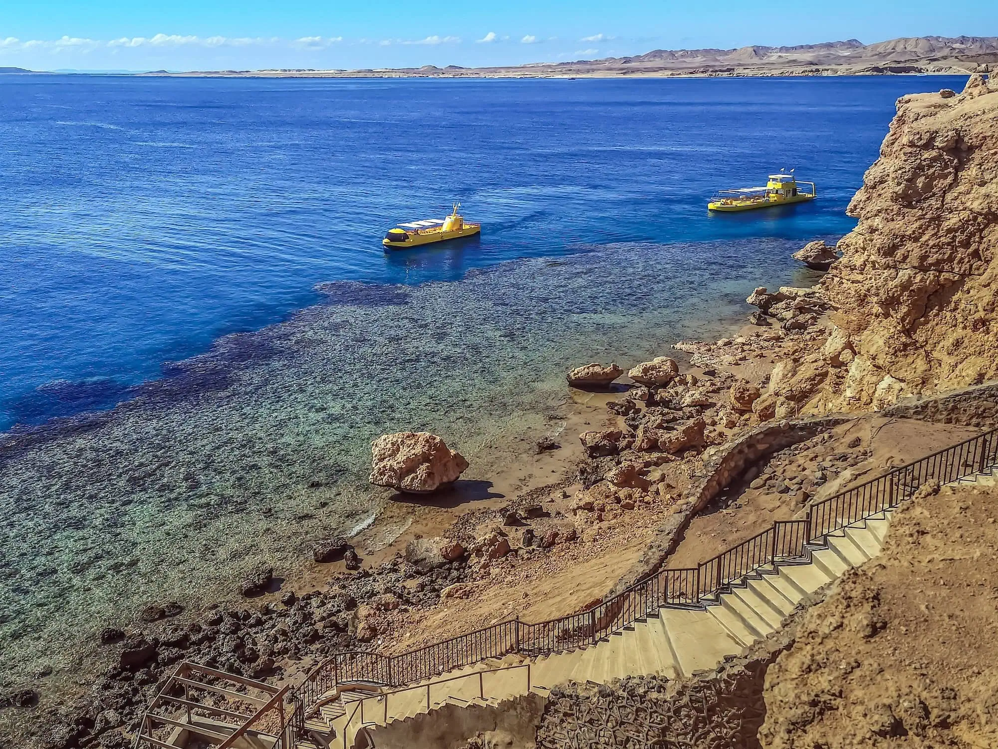 Two yellow tourist boats sailing above a coral reef in the Red Sea, Sharm El Sheikh