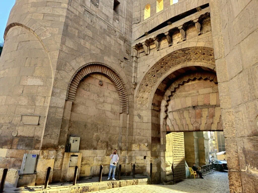 Bab al-Futuh gate opening onto Al-Muizz Street with massive stone towers and arched entrance, Bab al-Futuh, Cairo