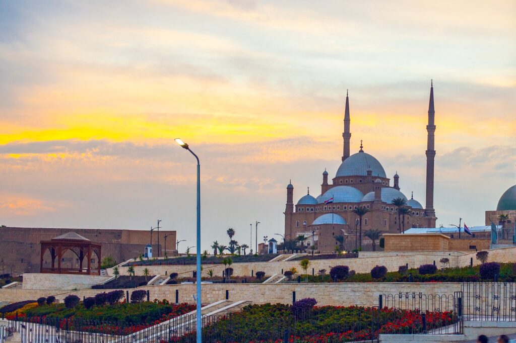 View of Salah Al-Din’s Citadel and the Mosque of Muhammad Ali at sunset with domes and minarets silhouetted against the sky, Cairo