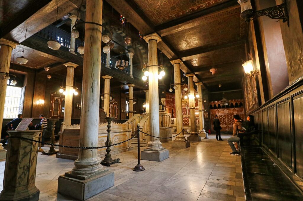 The main prayer hall with central bimah, wooden gallery, and decorative altar area inside the Ben Ezra Synagogue, Cairo