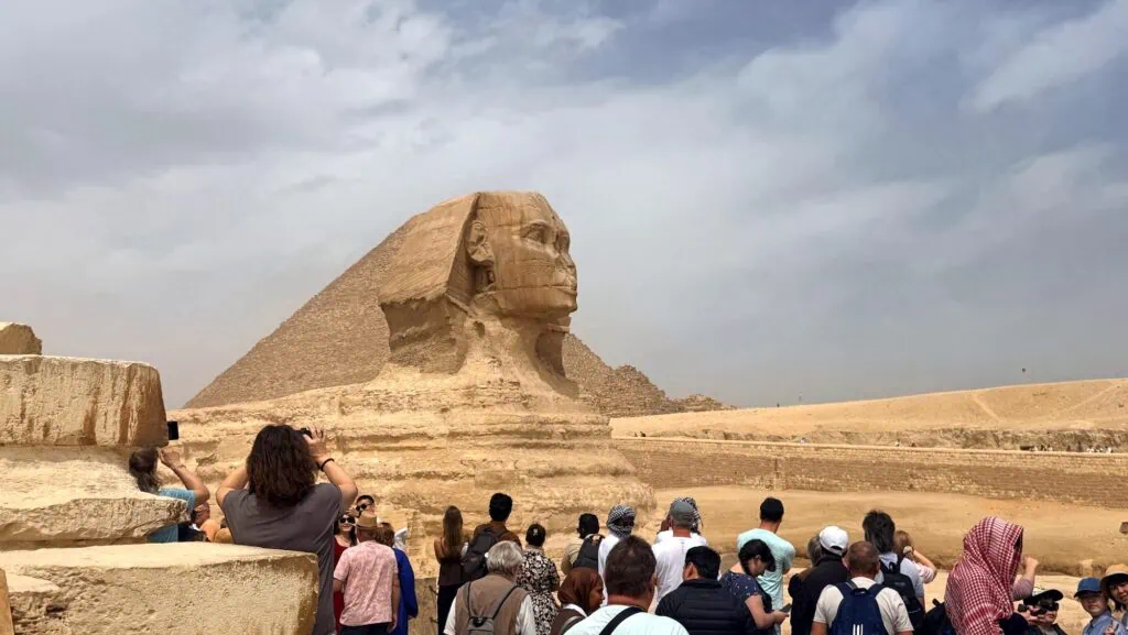 Great Sphinx of Giza with a pyramid rising behind it on the Giza Plateau, Cairo