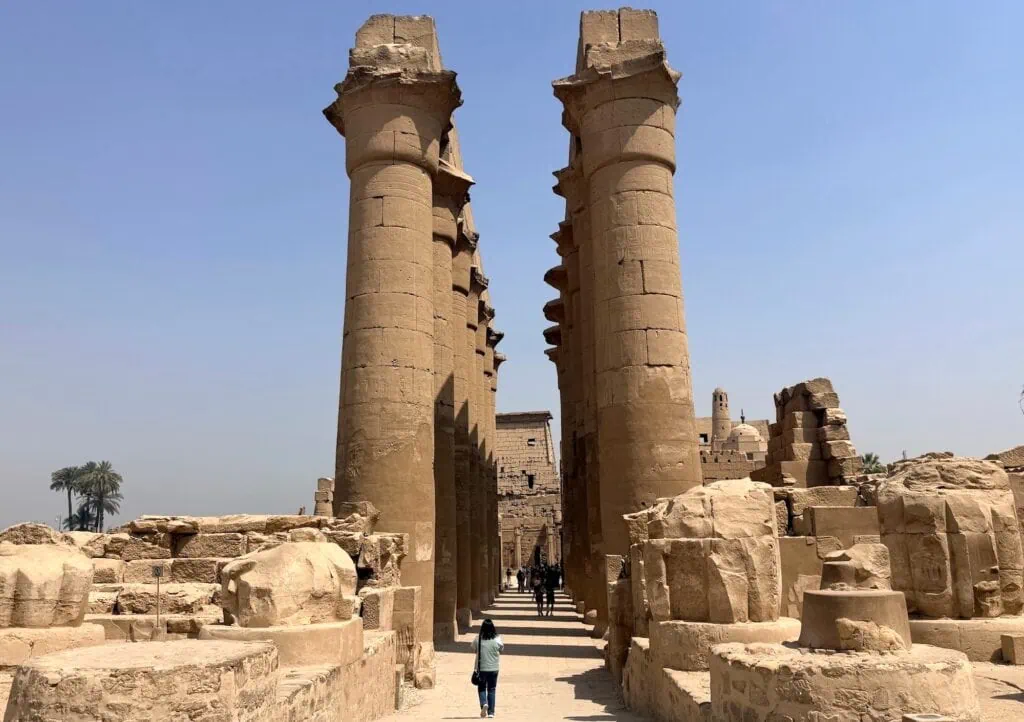 Rows of tall stone pillars with carved hieroglyphs inside Luxor Temple Luxor