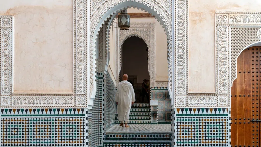 Moroccan man walking inside mausoleum of Moulay Ismail, final resting place of Moulay Ismail, a powerful Sultan who ruled Morocco during the 17th century.