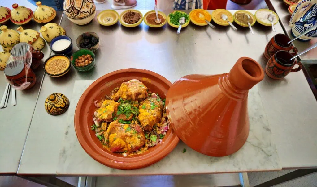 Chicken tagine served in a traditional dish with ingredients on display in Marrakech