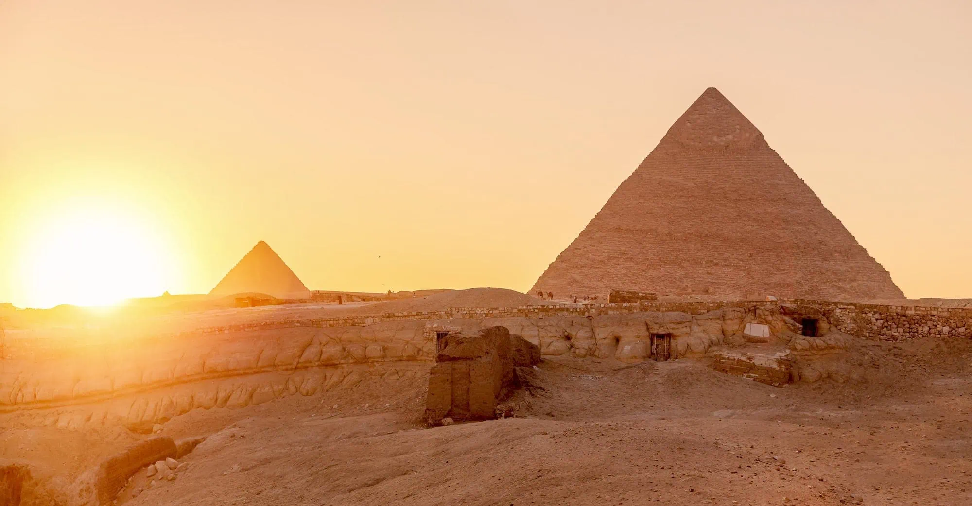 Great Pyramid of Giza at sunset with golden lighting and dramatic sky