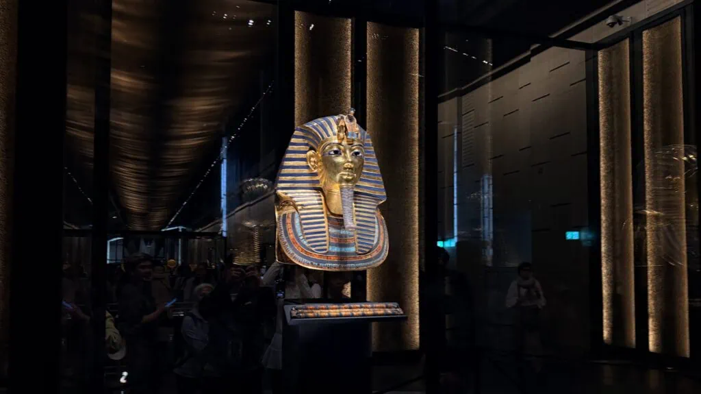 A close-up view of the golden funerary mask of King Tutankhamun, one of the most iconic treasures of ancient Egypt, displayed inside the Grand Egyptian Museum in Giza