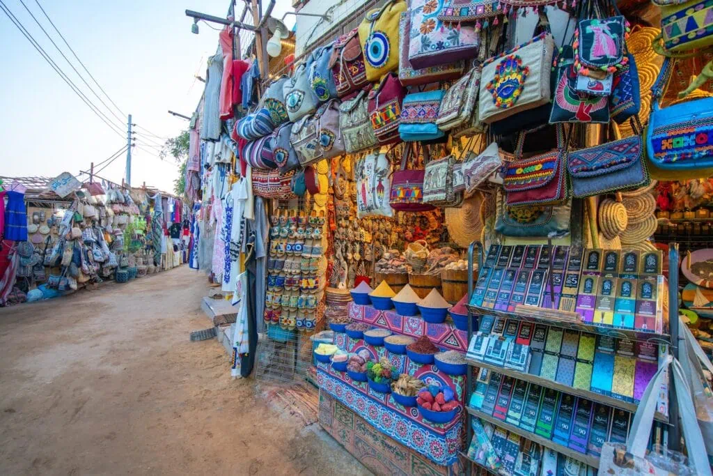 Nubian village market with colorful bags, spices, and handmade crafts displayed at dusk, Aswan